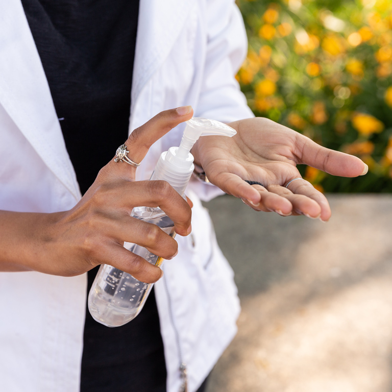 An IUPUI staffer uses hand sanitizer